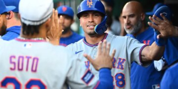 New York Mets left fielder Tyrone Taylor (28) is congratulated by teammates after scoring a run.