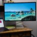 The Apple Studio Display on a small wooden desk with a MacBook Air next to it.