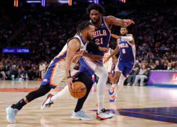 Jalen Brunson of the New York Knicks drives to the basket with Joel Embiid of the Philadelphia 76ers guarding him.
