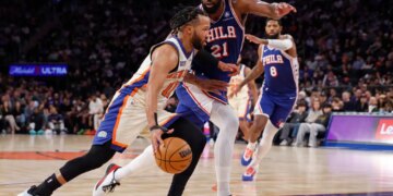 Jalen Brunson of the New York Knicks drives to the basket with Joel Embiid of the Philadelphia 76ers guarding him.