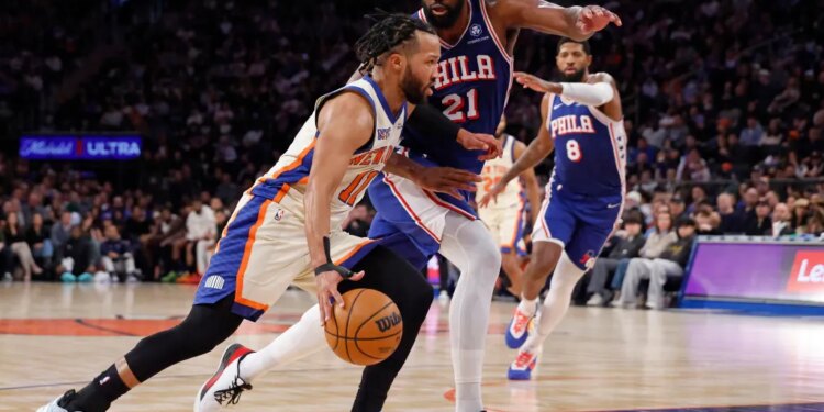 Jalen Brunson of the New York Knicks drives to the basket with Joel Embiid of the Philadelphia 76ers guarding him.