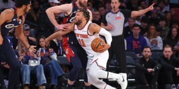 New York Knicks guard Jalen Brunson #11 drives to the basket as Cleveland Cavaliers forward Dean Wade #32 defends.