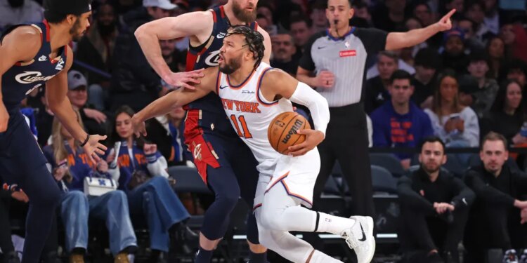 New York Knicks guard Jalen Brunson #11 drives to the basket as Cleveland Cavaliers forward Dean Wade #32 defends.