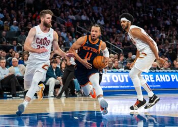 New York Knicks guard Jalen Brunson drives between Cleveland Cavaliers forward Dean Wade and center Jarrett Allen.
