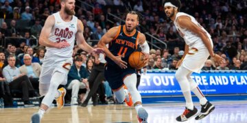 New York Knicks guard Jalen Brunson drives between Cleveland Cavaliers forward Dean Wade and center Jarrett Allen.