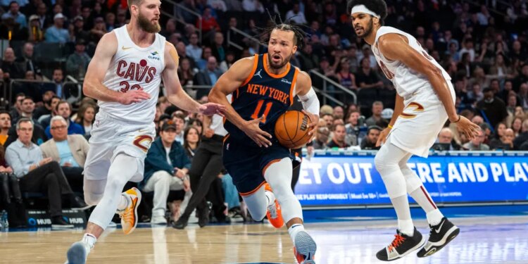 New York Knicks guard Jalen Brunson drives between Cleveland Cavaliers forward Dean Wade and center Jarrett Allen.