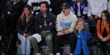 Actors Jason Bateman and Jason Sudeikis sitting courtside with their families at an NBA game.