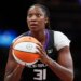 Tina Charles holding a basketball, looking up.