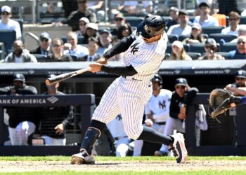 New York Yankees player Trent Grisham swings at a baseball during a game.