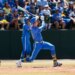 A baseball player in a blue and yellow uniform swinging a bat during a game.