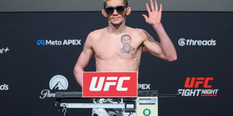 Melquizael Costa poses on the scale during the official weigh-in for UFC Fight Night.