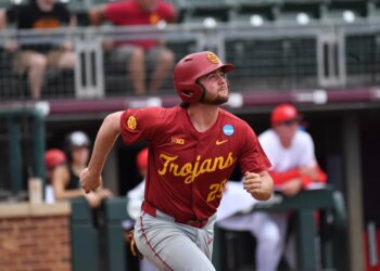 Andrew Lamb from the Trojans baseball team looking up while running.