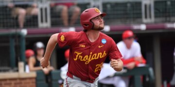 Andrew Lamb from the Trojans baseball team looking up while running.