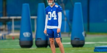 Dominic Zvada in New York Giants uniform #34 with a helmet on a practice field.