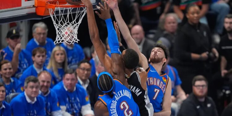 San Antonio Spurs forward Victor Wembanyama (1) shoots against Oklahoma City Thunder guard Shai Gilgeous-Alexander (2) and center Chet Holmgren (7) during the first half of Game 1 of the Western Conference finals.