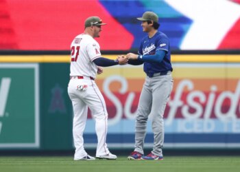 Shohei Ohtani of the Los Angeles Dodgers and Mike Trout of the Los Angeles Angels interact on the field.