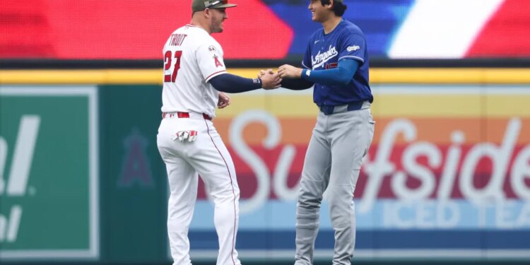 Shohei Ohtani of the Los Angeles Dodgers and Mike Trout of the Los Angeles Angels interact on the field.