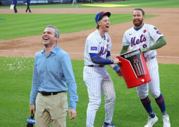 Mets players Brett Baty and Brandon Nimmo douse SNY's Steve Gelbs with Gatorade after a walk-off win against the Chicago White Sox.