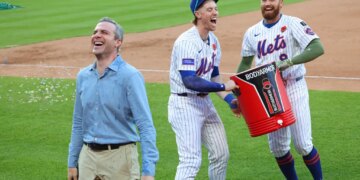 Mets players Brett Baty and Brandon Nimmo douse SNY's Steve Gelbs with Gatorade after a walk-off win against the Chicago White Sox.
