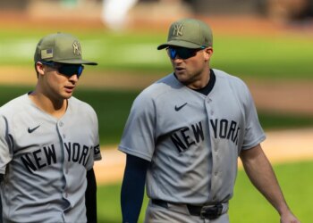 New York Yankees players Anthony Volpe and Max Schuemann walking off the field after a loss.