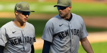 New York Yankees players Anthony Volpe and Max Schuemann walking off the field after a loss.