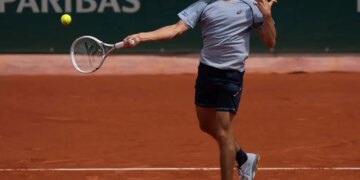 Zachary Svajda hitting a forehand return during a tennis match at the French Open.