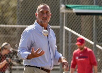 John Mozeliak, President of Baseball Operations for the St. Louis Cardinals, tossing a baseball.