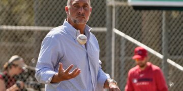 John Mozeliak, President of Baseball Operations for the St. Louis Cardinals, tossing a baseball.