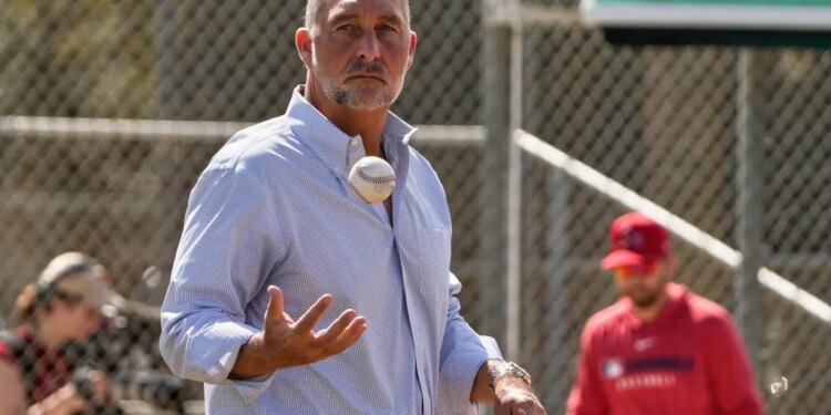 John Mozeliak, President of Baseball Operations for the St. Louis Cardinals, tossing a baseball.
