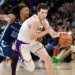 Austin Reaves of the Lakers handling the ball against Ja Morant of the Grizzlies.