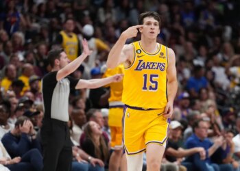 Lakers player Austin Reaves pointing to his head during a game.