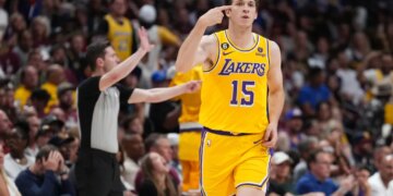 Lakers player Austin Reaves pointing to his head during a game.