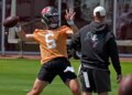 Baker Mayfield in an orange jersey throwing a football.