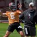 Baker Mayfield in an orange jersey throwing a football.