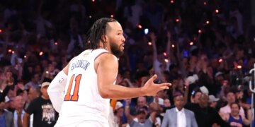 New York Knicks guard Jalen Brunson #11 reacts after he sinks a three-point shot over San Antonio Spurs forward Victor Wembanyama #1 to bring the Knicks within one during the fourth quarter of NBA Finals Game 4.