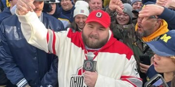 Big Ev from Barstool Sports speaking into a microphone, surrounded by a crowd.