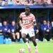 United States forward Tim Weah (21) on the field with a soccer ball.