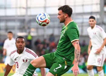 Ireland's Troy Parrott controls the ball in the air ahead of Qatar's Assim Madibo.