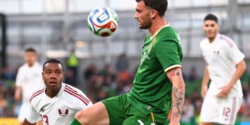 Ireland's Troy Parrott controls the ball in the air ahead of Qatar's Assim Madibo.