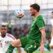 Ireland's Troy Parrott controls the ball in the air ahead of Qatar's Assim Madibo.