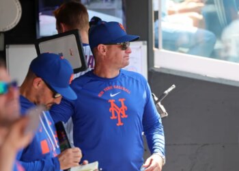 New York Mets manager Carlos Mendoza #64 in the dugout.