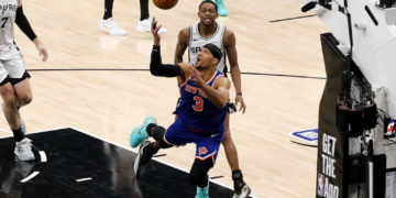 New York Knicks guard Josh Hart (3) and San Antonio Spurs guard De'aaron Fox (4) look for the ball during game five of the 2026 NBA Finals at Frost Bank Center.