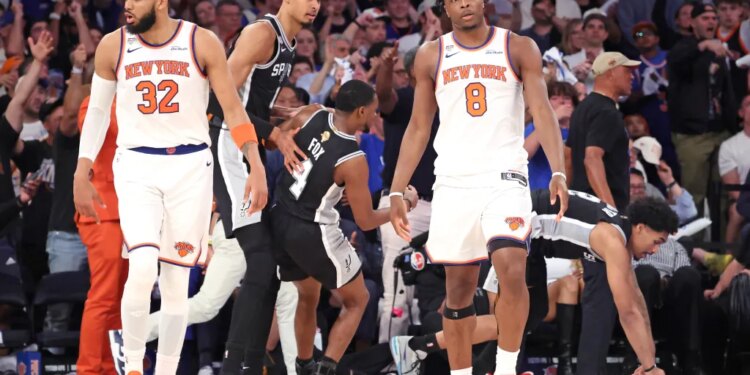 New York Knicks center Karl-Anthony Towns #32 and forward Og Anunoby #8 react on the court as San Antonio Spurs players walk by during the NBA Finals Game 3.