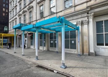 Models of proposed sidewalk sheds in teal and yellow on a city street.
