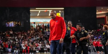 Washington Mystics coach Sydney Johnson is escorted off the court by police after being ejected during a game against the Dream on June 6, 2026.