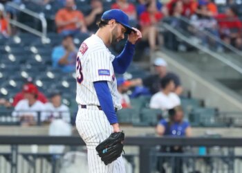 New York Mets pitcher David Peterson adjusts his hat after giving up a 2-run home run.