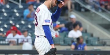 New York Mets pitcher David Peterson adjusts his hat after giving up a 2-run home run.