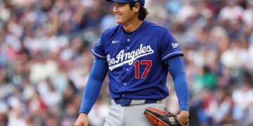 Dodgers starting pitcher Shohei Ohtani smiles after a play during a game.