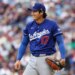 Dodgers starting pitcher Shohei Ohtani smiles after a play during a game.