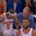 New York Knicks player number 5 falling into the stands and interacting with a man in a blue sweater.